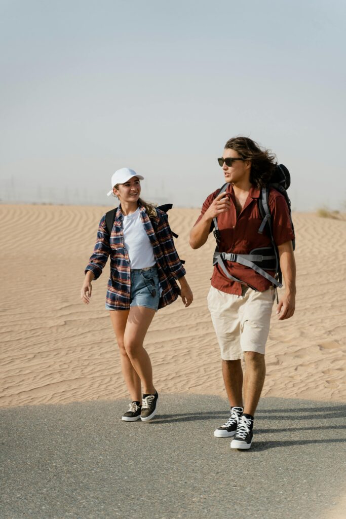 pexels-photo-8869378-8869378 A man and woman hiking together in a sunny desert, enjoying an adventure.