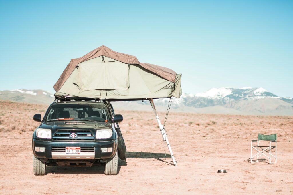 pexels-photo-9633340-9633340 Outdoor adventure in Oreana Desert featuring SUV with rooftop tent and scenic mountains.